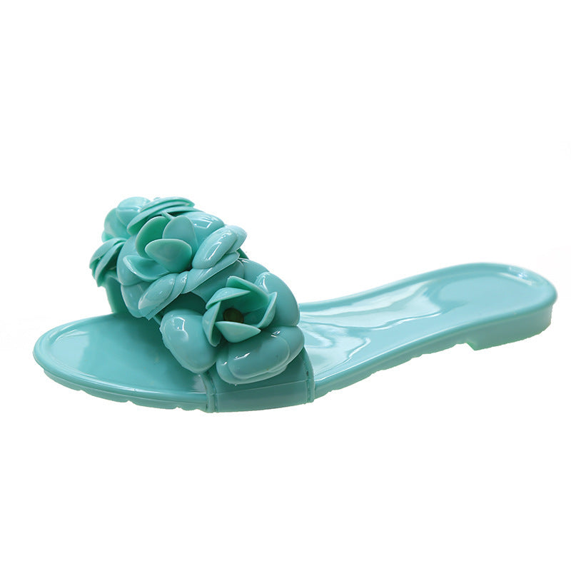 Turquoise sandal with floral design on a white background