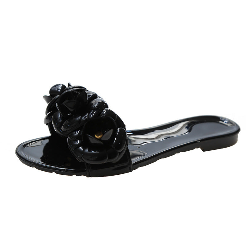 Black sandal with a decorative flower on a white background