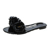 Black sandal with a decorative flower on a white background