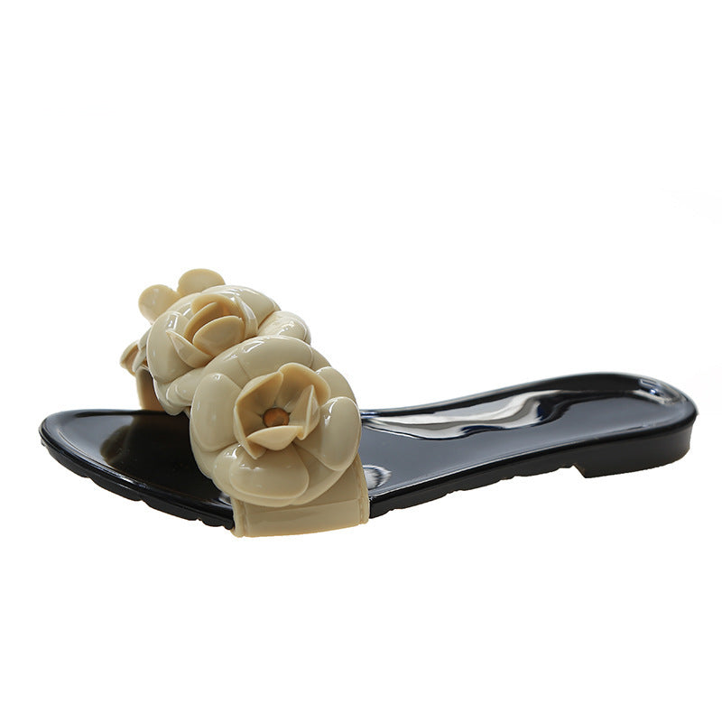 Black sandal with beige floral decorations on a white background