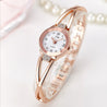 Rose gold wristwatch with diamond accents on a light background