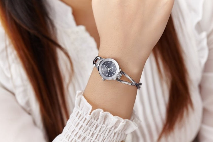 Silver watch on a wrist with a blurred background