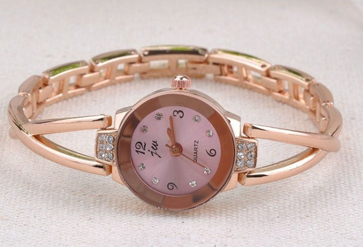 Rose gold watch with pink face on a white background