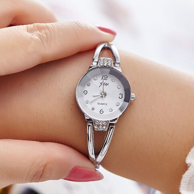 Silver wristwatch with gemstone accents on a wrist