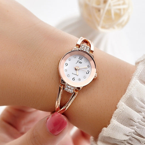 Rose gold watch on a wrist with a blurred background